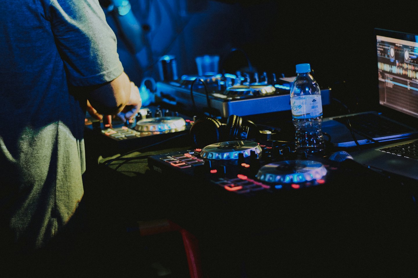 DJ che suona musica su un controller in un locale.
